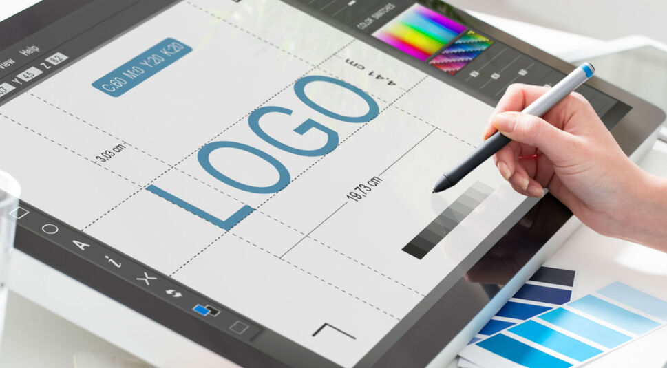 Hand zeichnet am Tablet ein Logo.