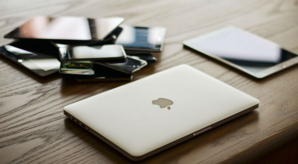 Ein Stapel an Smartphones, Tablets und einem Macbook von Apple.