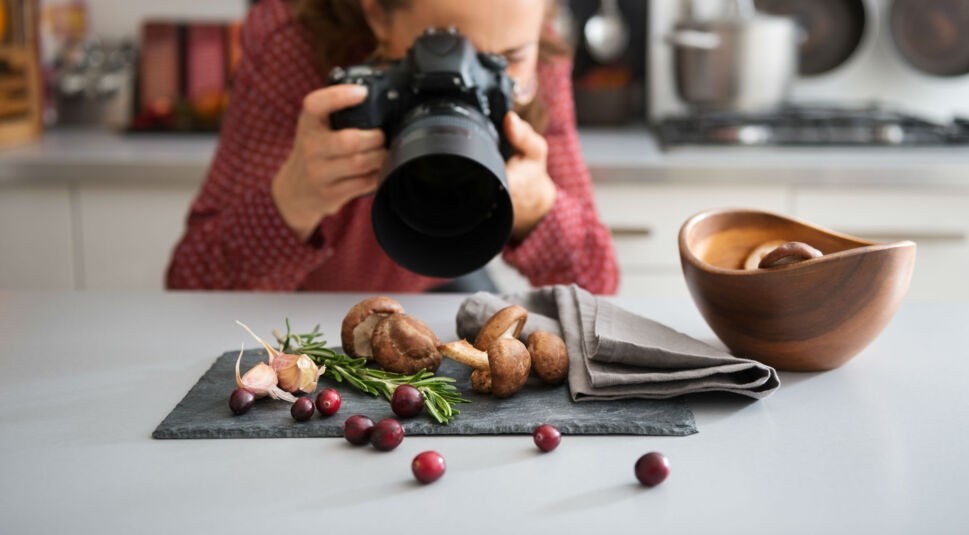 Junge Frau fotografiert Essen für ihren Blog.