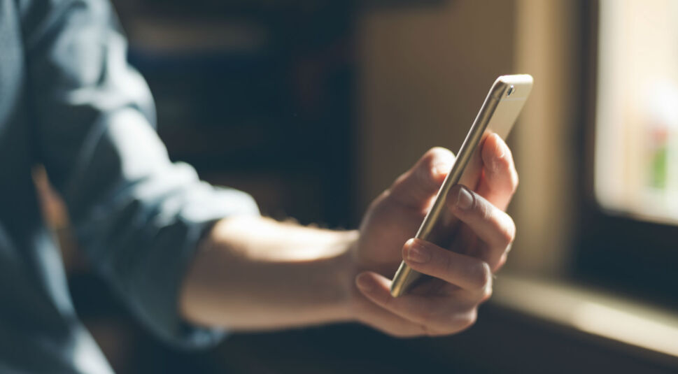 Ausgestreckter Arm mit iPhone in der Hand