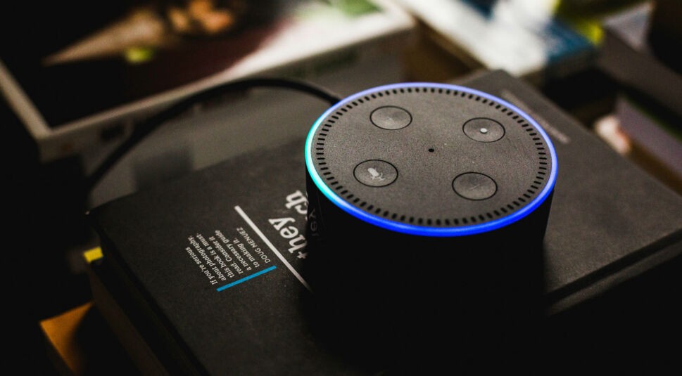 Der schwarze Amazon Echo Dot auf einem Stapel Bücher.