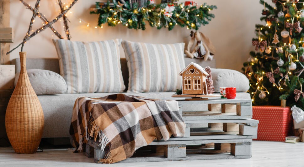 Ein weihnachtlich geschmücktes Wohnzimmer mit Couch, Tisch und Dekoration.