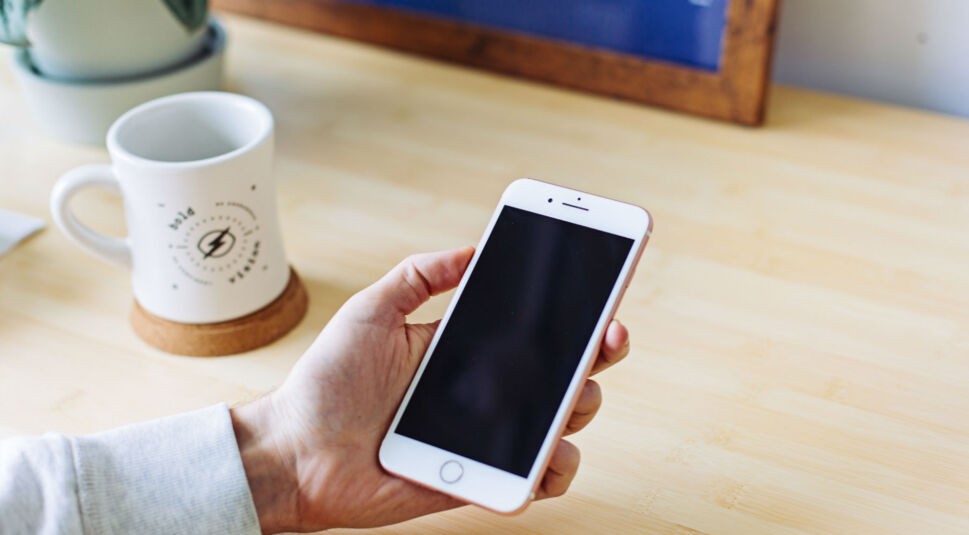 Ein iPhone liegt in der Hand.