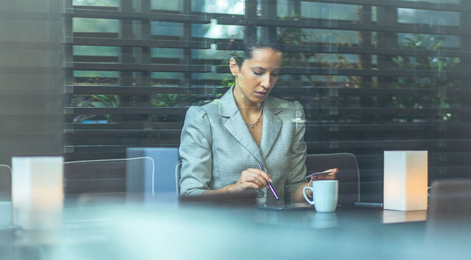 Junge Frau schaut auf ihr Tablet und denkt nach.