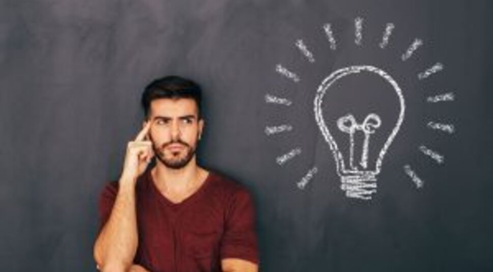 Junger Mann löst Denkspiele.