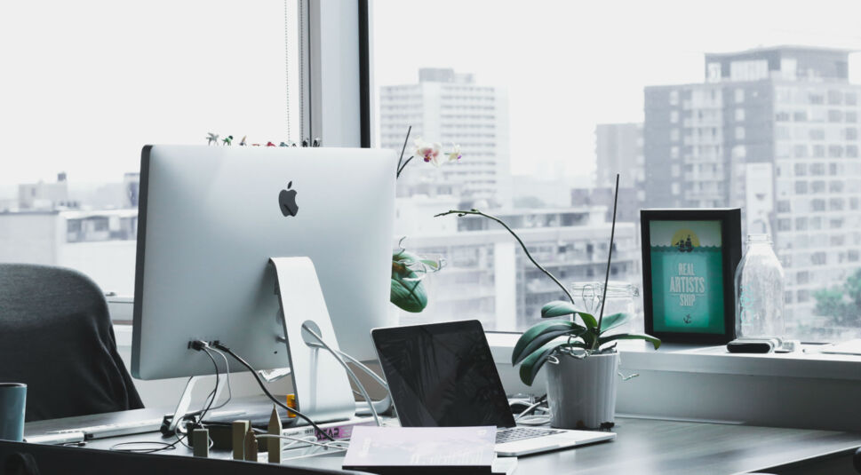 Mac-Computer steht auf Schreibtisch im Büro.
