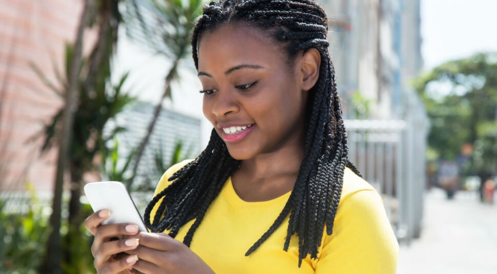 Junge Frau verwendet Zwei-Faktor-Authentifizierung auf ihrem Smartphone.