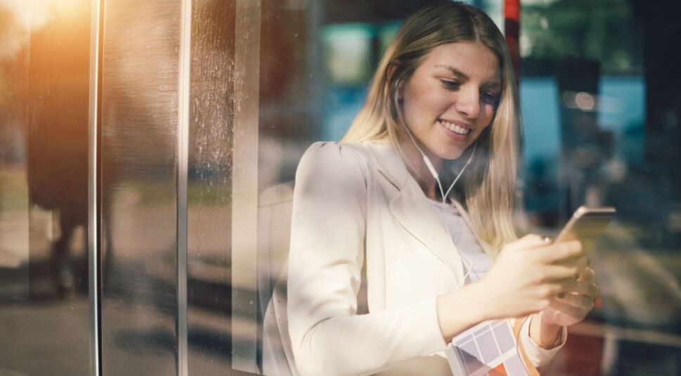 Junge Frau kontrolliert am Smartphone ihre Bildschirmzeit.