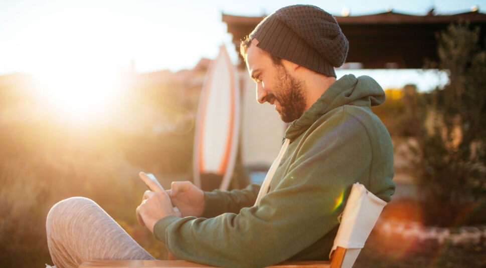 Mann-mit-Smartphone-am-Strand