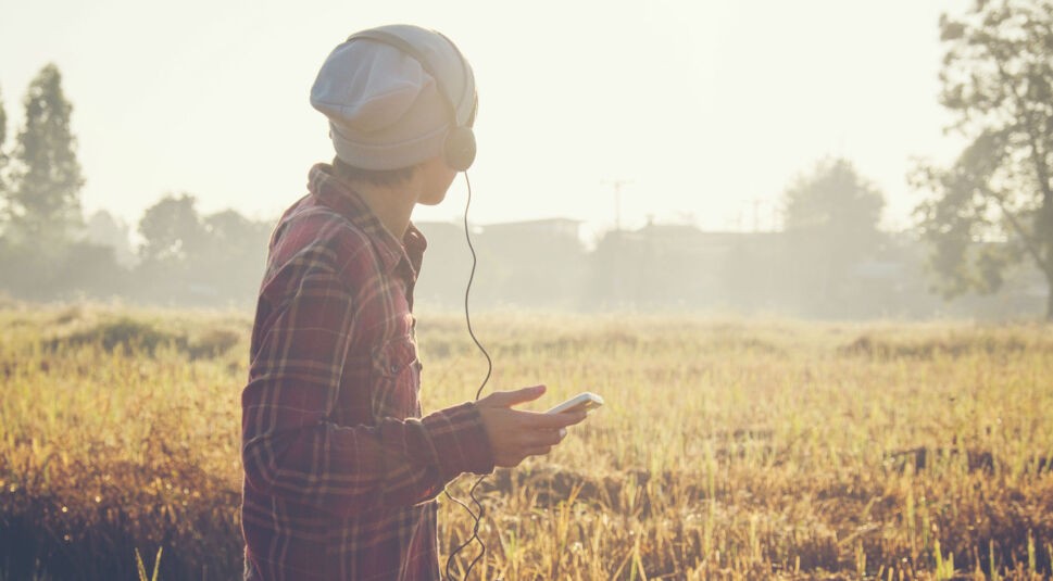 Junger Mann streamt Musik über sein Smartphone.