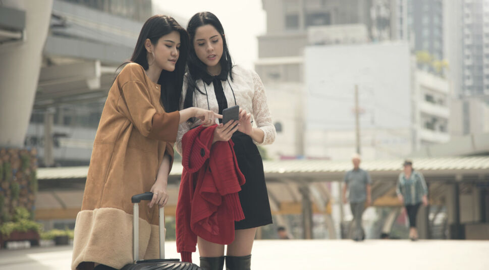 Zwei Freundinnen planen ihre Route mit dem Smartphone.