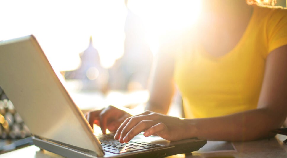 Junge Frau erstellt am Laptop ihre eigene Schriftart.