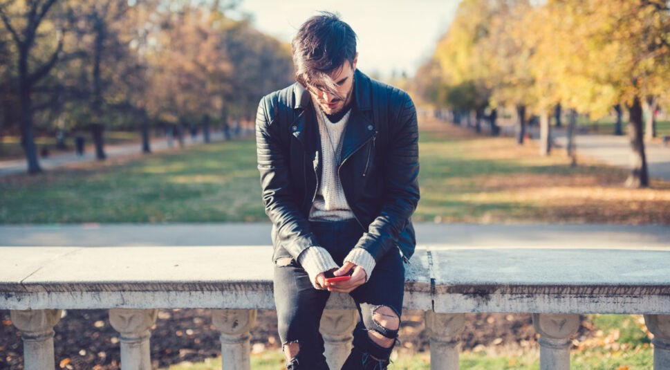 Junger Mann deaktiviert Googles Standortermittlung am Smartphone.