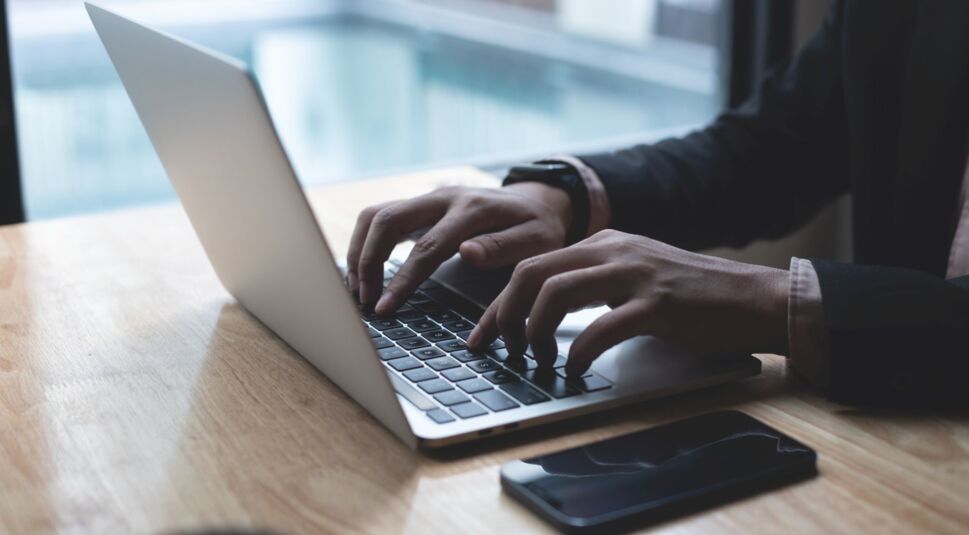 Mann tippt auf dem MacBook