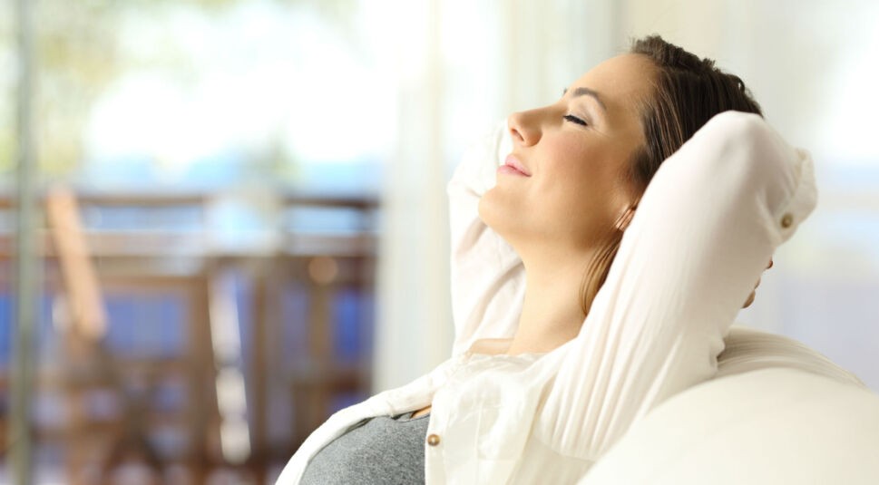 Junge Frau entspannt sich auf dem Sofa, nachdem sie Android P getestet hat.