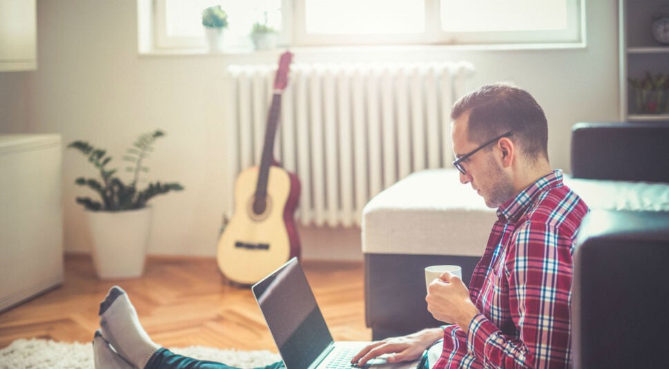Junger Mann spielt ein Windows-Spiel auf seinem MacBook.