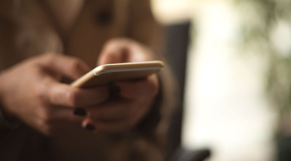 Junge Frau nutzt ihr iPhone mit iOS 12.