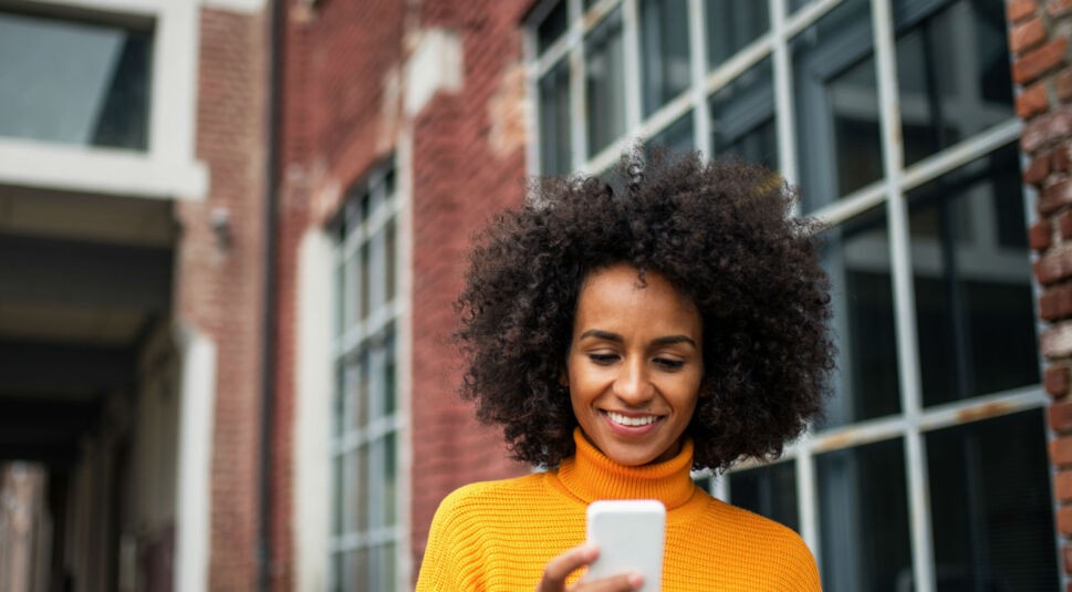 Junge Frau nutzt den Google Assistant am Smartphone.