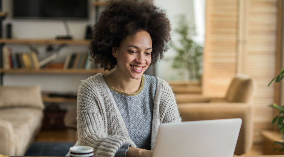 Junge Frau sucht am Laptop nach alten Schulfreunden.