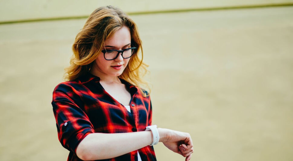 Junge Frau sieht auf ihre gereinigte Apple Watch.
