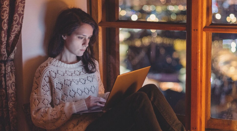 Junge Frau repariert am Laptop die Outlook-Suche.