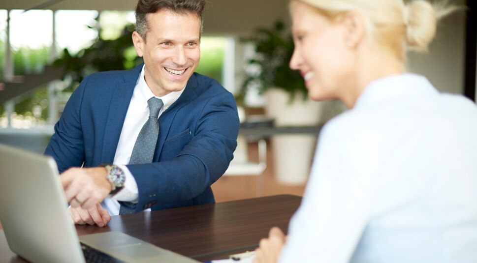 Zwei Kollegen beraten über einem Docs-Dokument