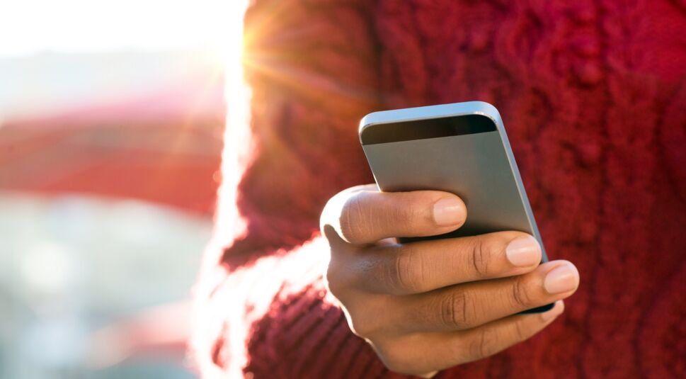 Eine junge Frau schreibt eine Nachricht auf ihrem iPhone