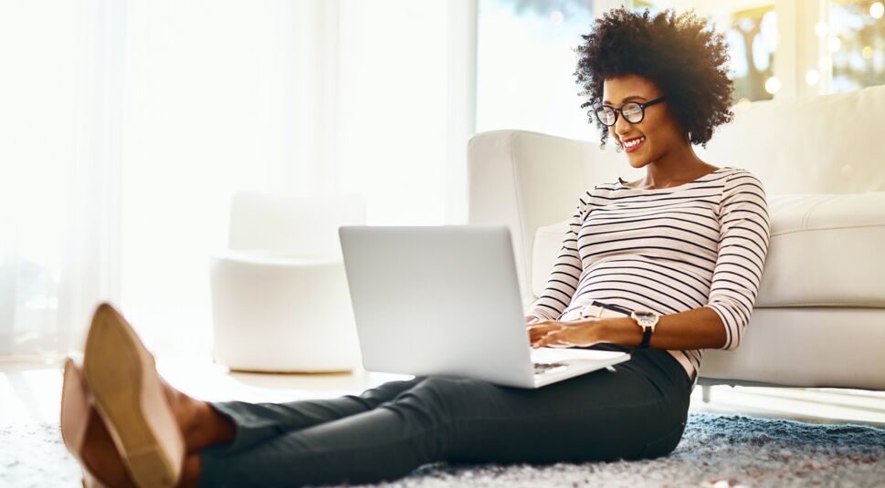 Eine Frau checkt im Home Office im Mails