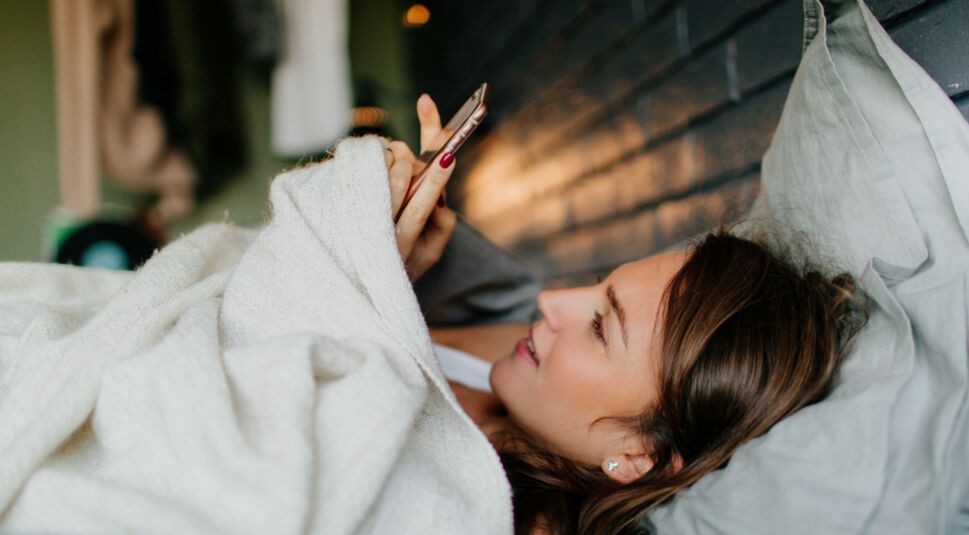 Junge Frau richtet ein neues Samsung Theme auf ihrem Smartphone ein.