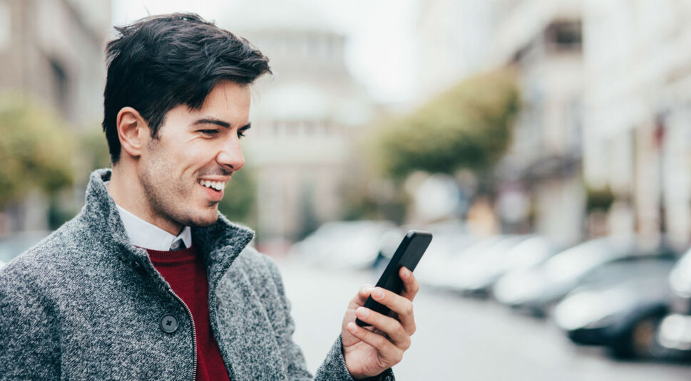 Junger Mann navigiert am Smartphone mit Google Maps.