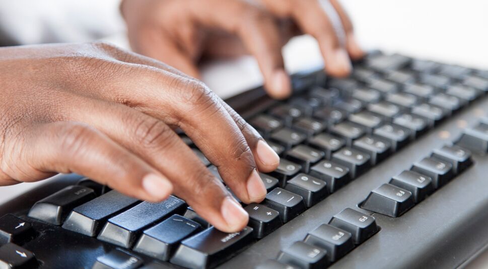 Mann schreibt auf Tastatur