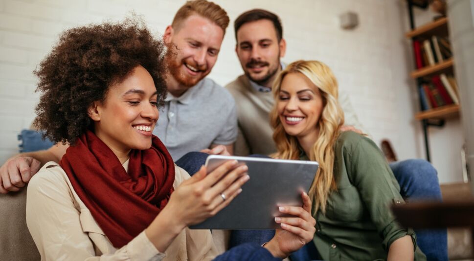 Freunde schauen sich Bilder auf dem iPad an