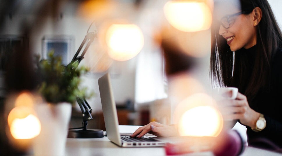 Frau kauft im iTunes Store am MacBook neue Musik.