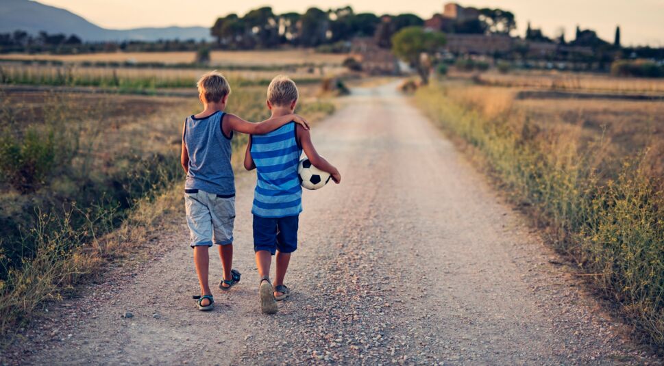 Zwei Freunde gehen nach dem Fußball nach Hause