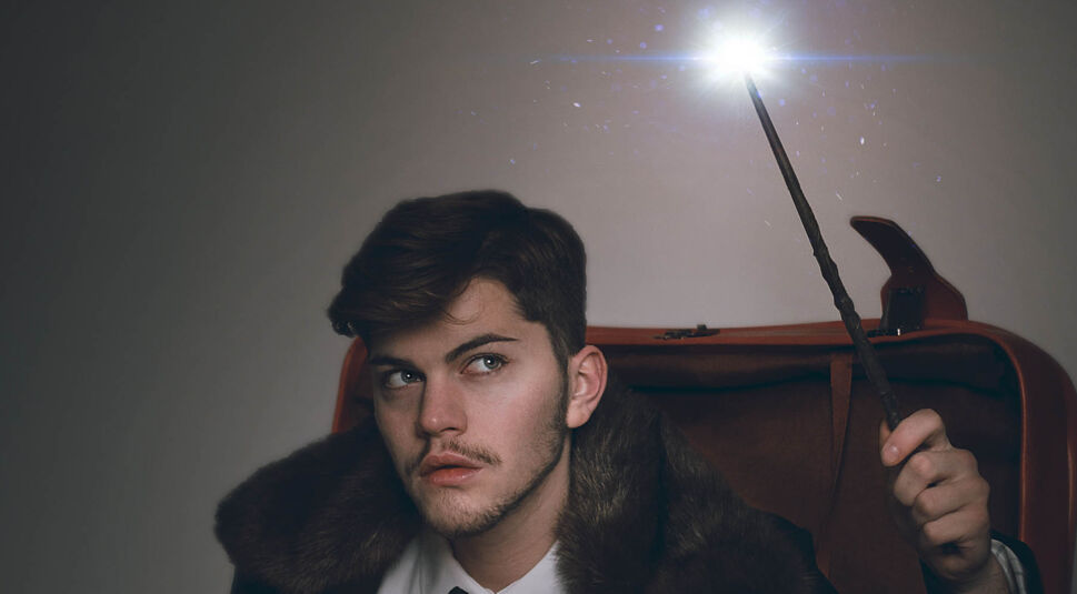 Junger Magier zaubert mit seinem Harry-Potter-Zauberstab.