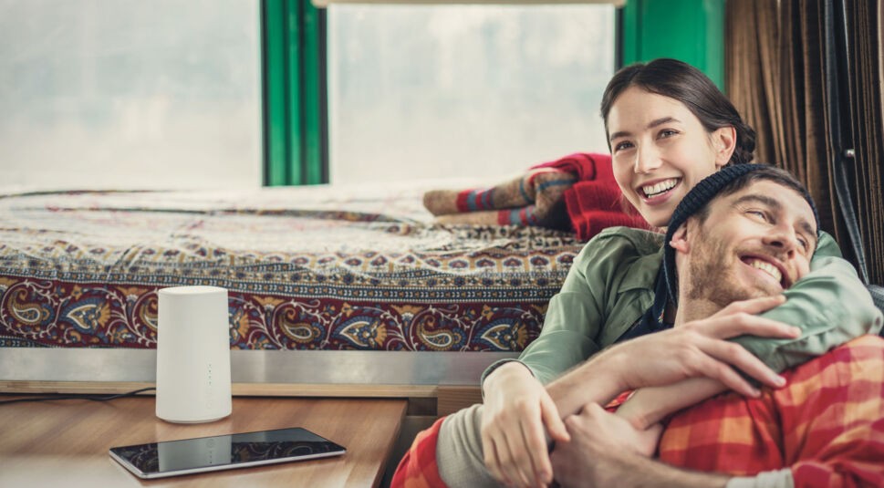 Ein Paar sitzt im Van und nutzt den GigaCube von Vodafone 