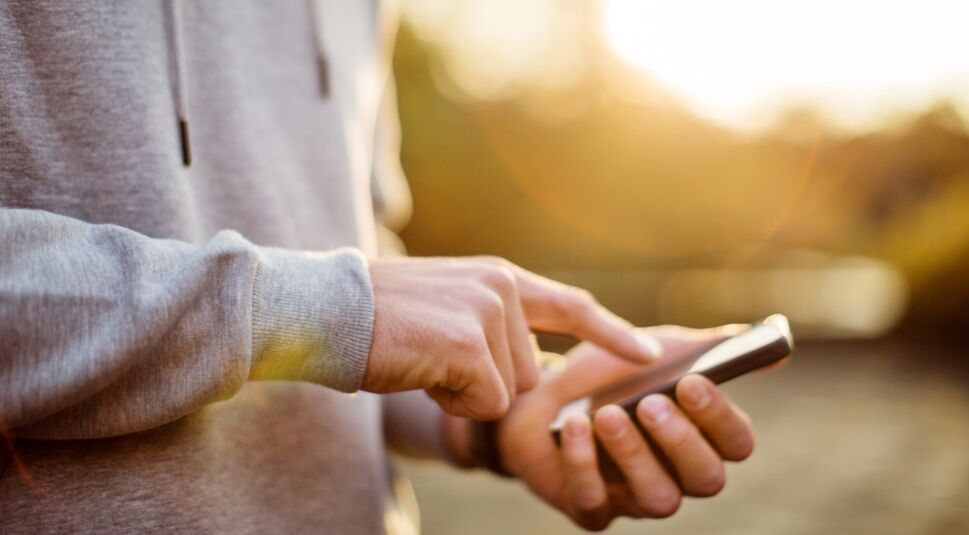 Mann tippt auf Smartphone.