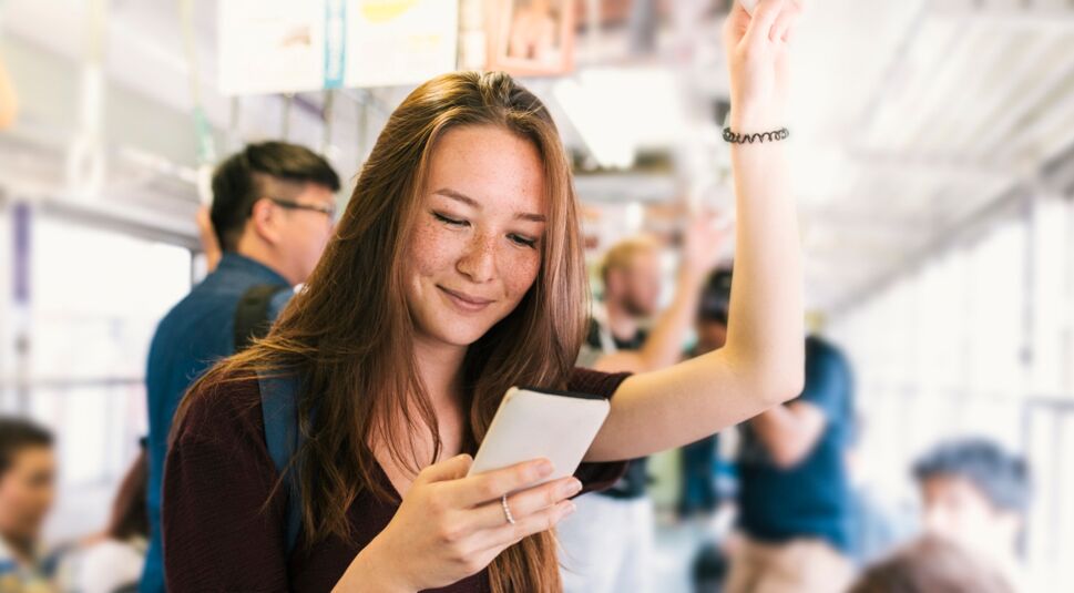 Junge Frau streamt Netflix im Bus.