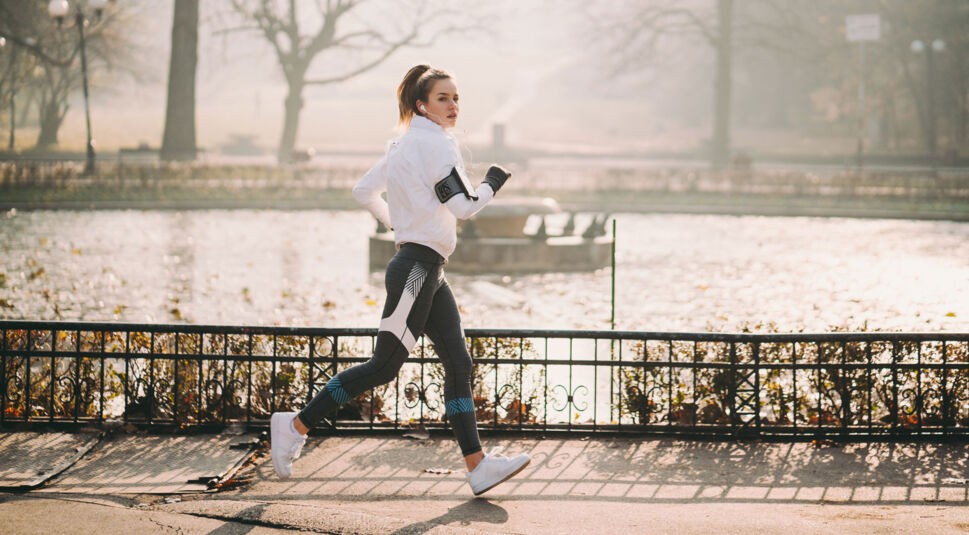 Eine joggende Frau, die sich mit Fitness-Tracker und Sport-Apps fit hält