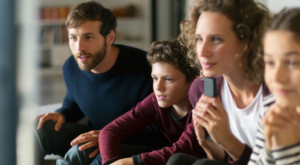 Vater, Mutter, Sohn und Tochter schauen kostenlose GigaTV-Kids-Inhalte