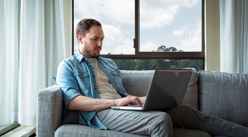 Ein Mann telefoniert mit Kopfhörern über seinen Laptop.