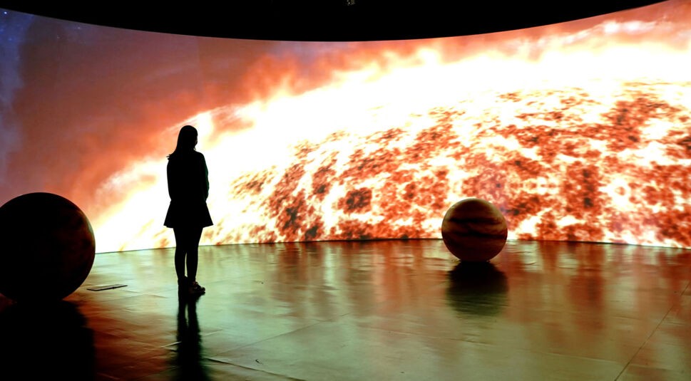 Eine Frau besucht eine Ausstellung zum Roman "Die drei Sonnen"