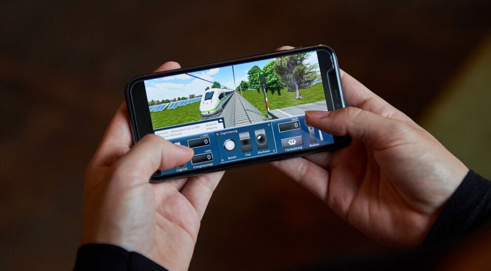 Eine Person spielt den DB Zug Simulator auf seinem Smartphone