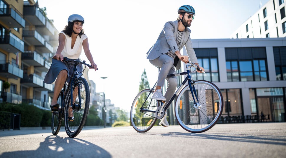 Ein Paar ist in der Stadt mit zwei Fahrrädern unterwegs.