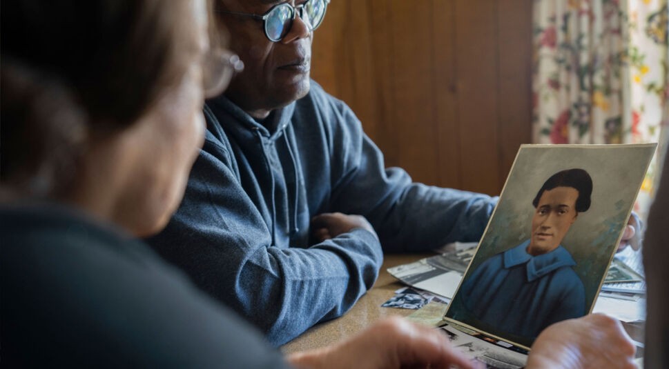 Schauspieler Samuel L. Jackson betrachtet mit einer Frau eine bunte Zeichnung einer junger schwarzen Frau.