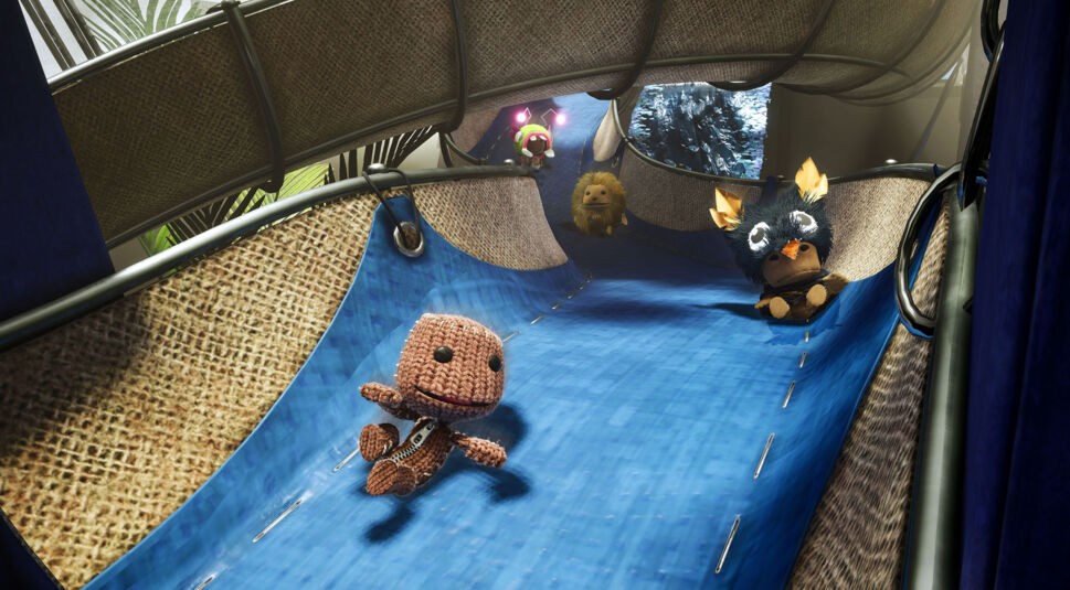 Sackboy rutscht im Spiel Sackboy: A Big Adventure eine Stoffbahn hinunter.