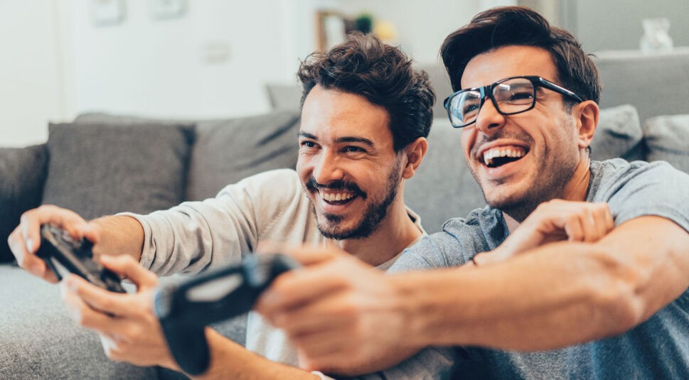 Zwei junge Männer spielen ein Game auf der PlayStation