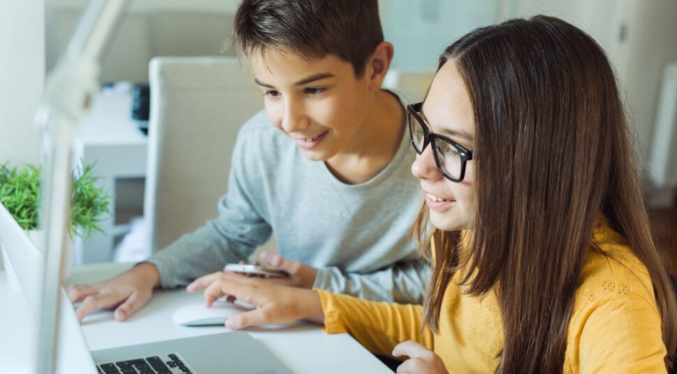 Zwei Kinder sitzen vor dem Laptop
