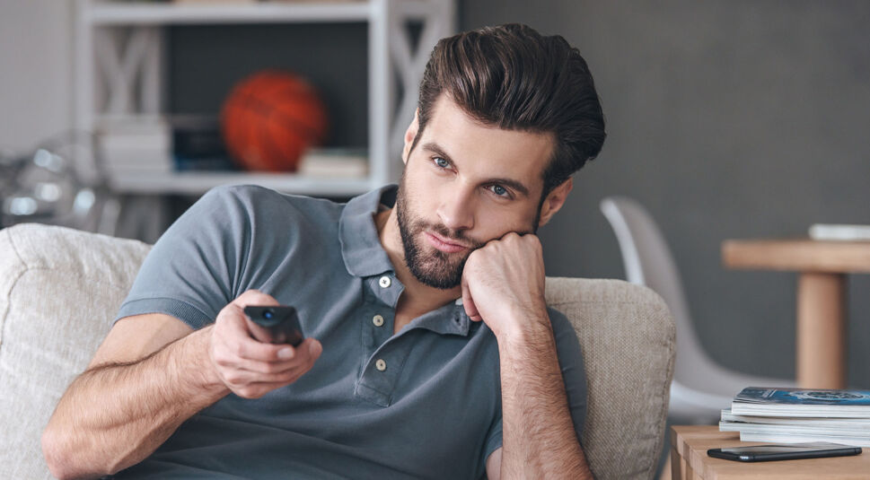 Genervter Mann mit Fernbedienung