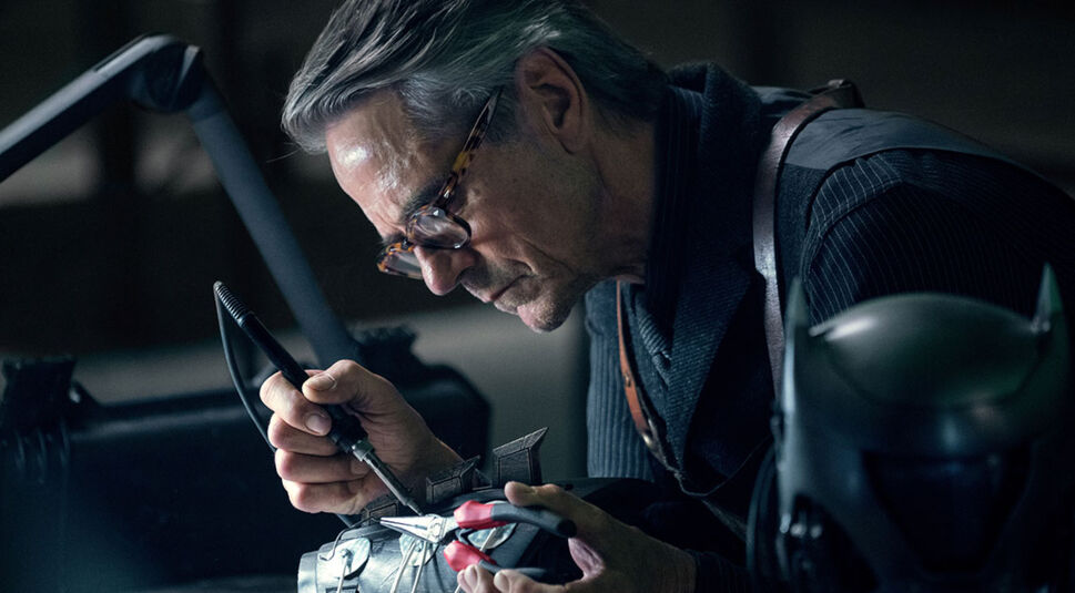 Butler Alfred (Jeremy Irons) repariert Ausrüstung im Film "Zack Snyder's Justice League".